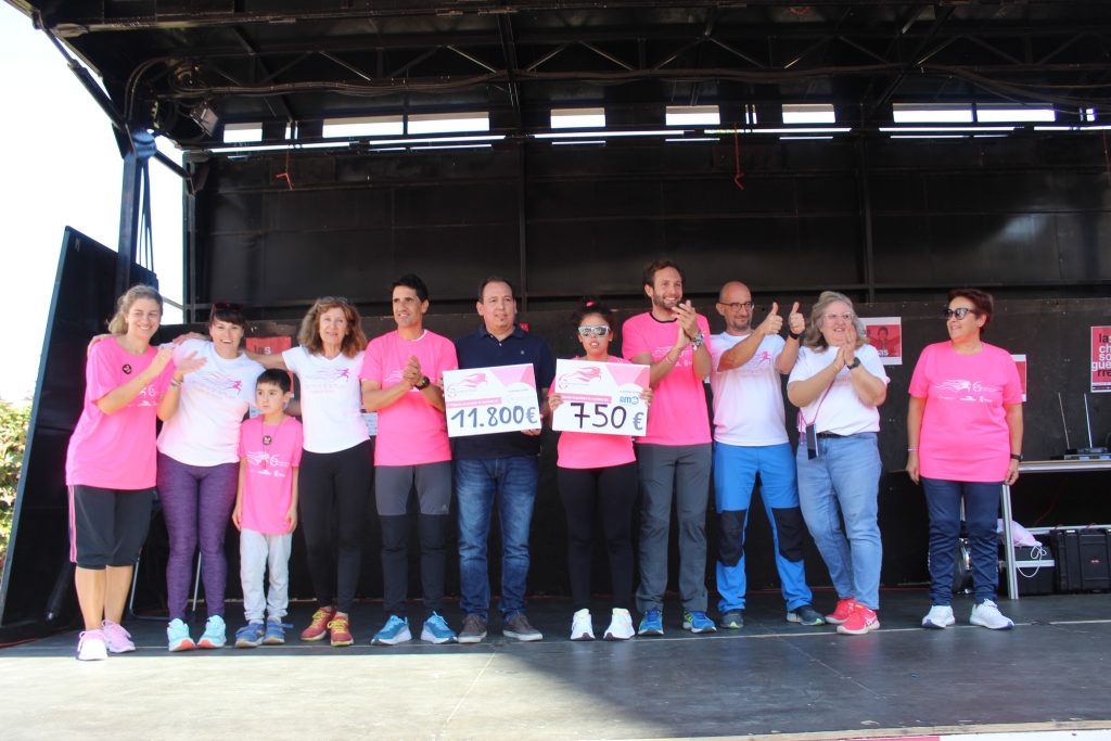 Grupo de personas pertenecientes a AMO, Instituto de Investigación sanitaria, ayuntamiento y organización con los cheques de las dos donaciones