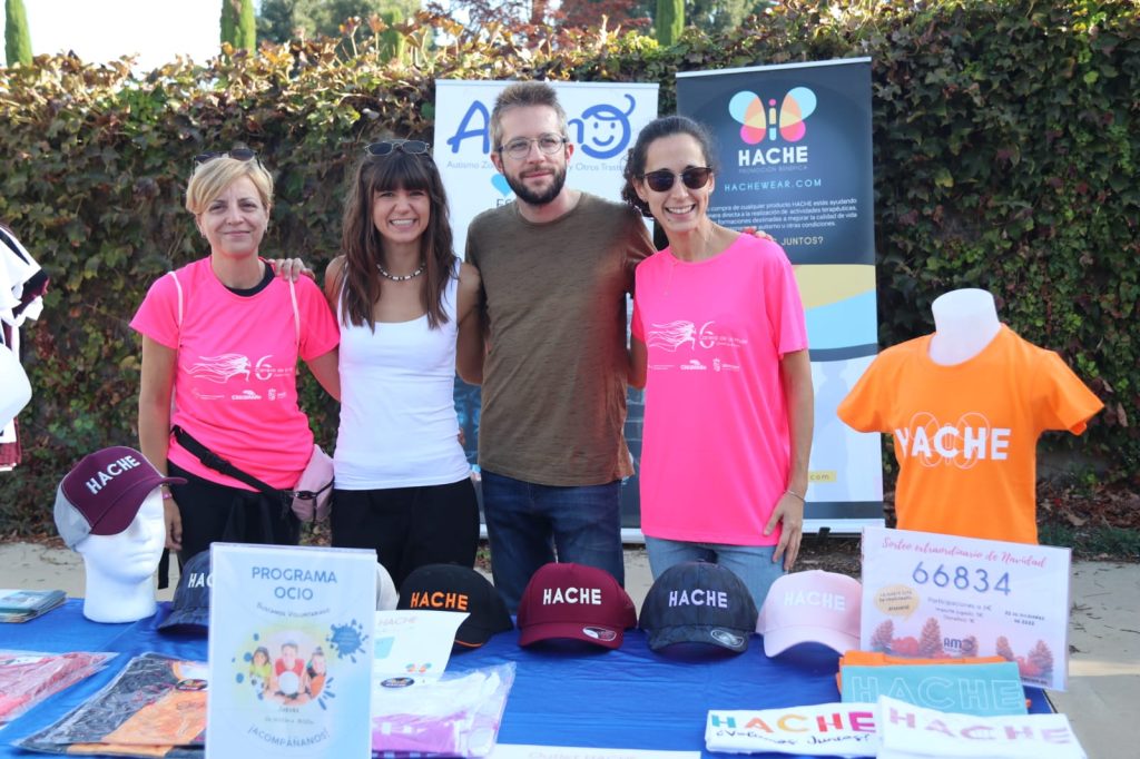 3 personas del equipo y una familia detrás del stand de Hache